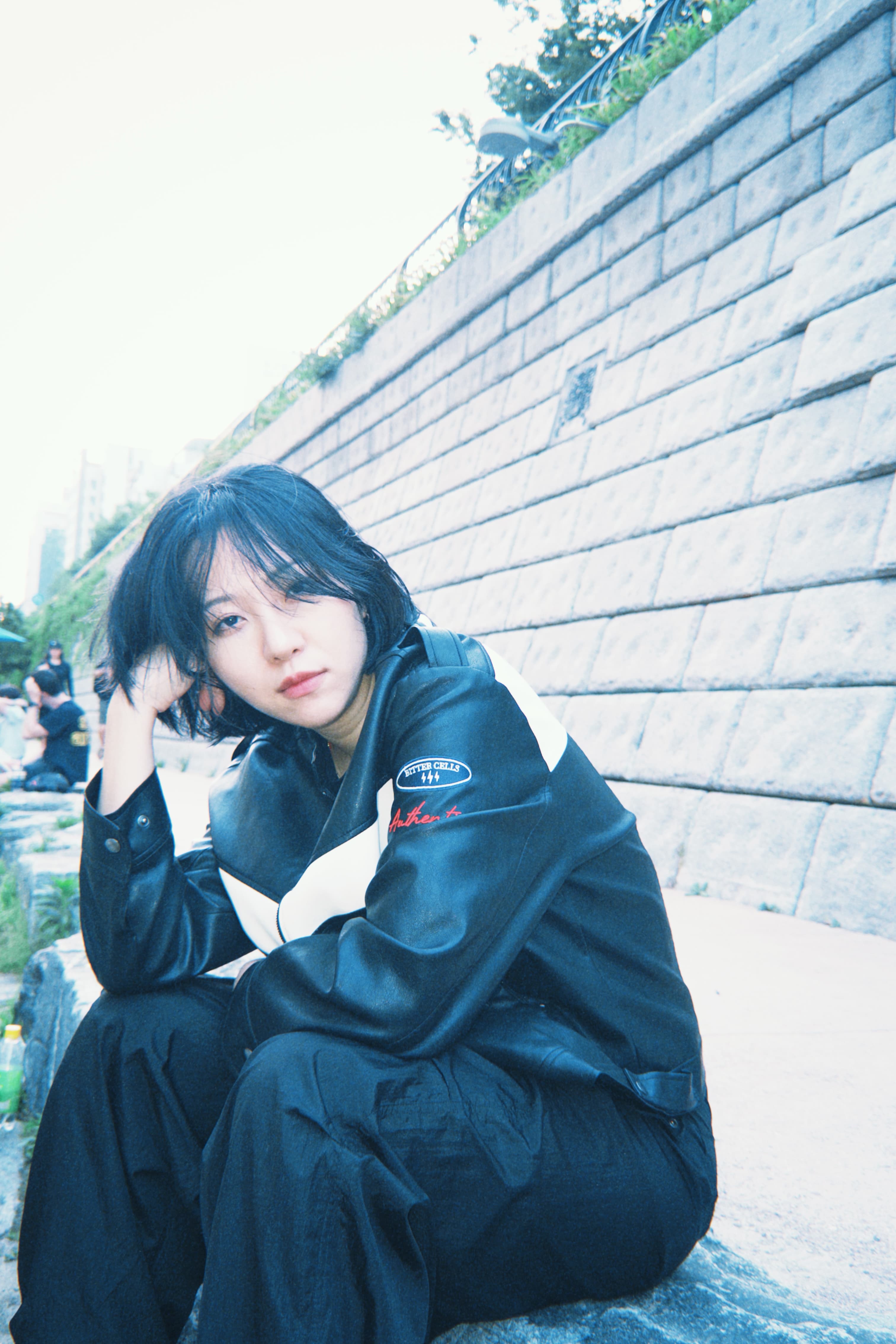 돌담 앞에 앉아 있는 프로필 사진
